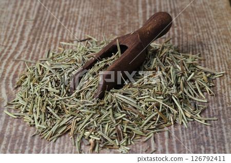 Dry organic background or texture of rosemary leaves. Healthy food concept . a wooden spoon with rosemary Dry organic background or texture of rosemary leaves. Healthy food concept . a wooden spoon with rosemary 126792411