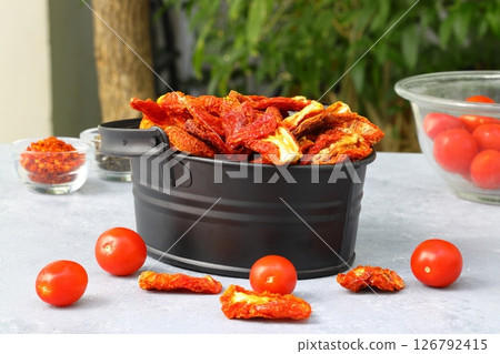 Bowl of sun dried tomatoes on wooden background. Sun dried tomatoes with fresh herbs and spices Bowl of sun dried tomatoes on wooden background. Sun dried tomatoes with fresh herbs and spices 126792415