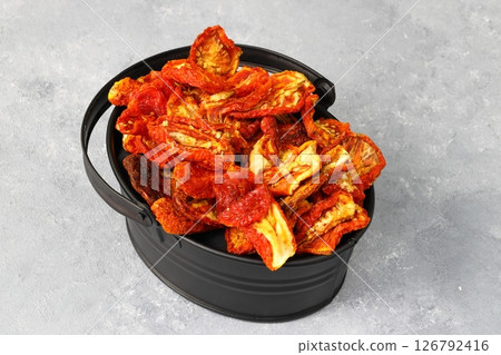 Bowl of sun dried tomatoes on wooden background. Sun dried tomatoes with fresh herbs and spices Bowl of sun dried tomatoes on wooden background. Sun dried tomatoes with fresh herbs and spices 126792416