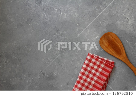 Wooden spoon and checkered tablecloth on stone background 126792810