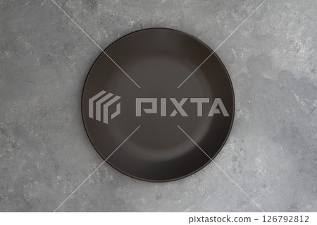 Empty black slate plate on dark stone table. Food background for menu, recipe. Table setting. Empty black slate plate on dark stone table. Food background for menu, recipe. Table setting. 126792812