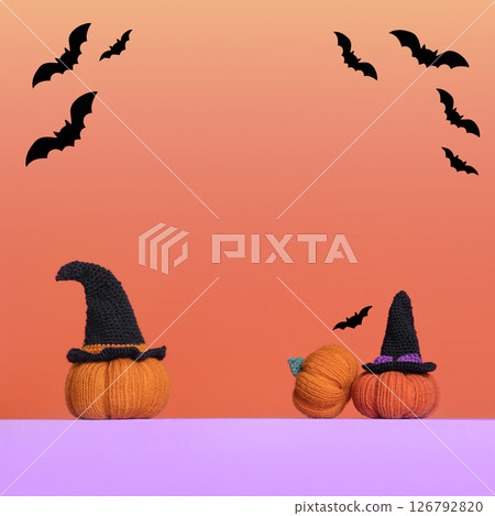 Knitted orange pumpkins with black witch hat and bats on orange gradient background, autumn composition, front view. Halloween concept. Knitted orange pumpkins with black witch hat and bats on orange gradient background, autumn composition, front view. Halloween concept. 126792820