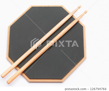 Drums rubber pad and wooden sticks isolated on white. Music school education kit. 126794768