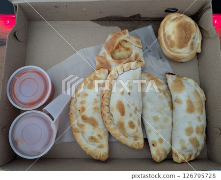 Empanada is a traditional Argentine dish. Several empanadas with different fillings in a delivery box 126795728
