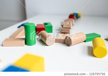 Colorful wooden building blocks on white surface for creative play 126795792