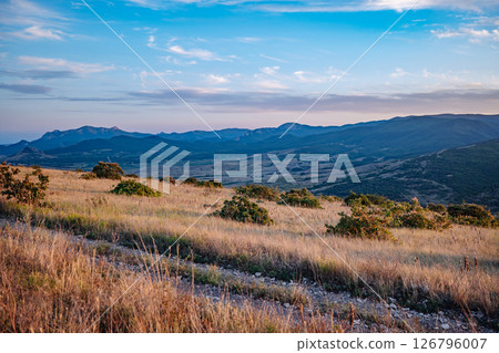 Scenic Crimean Landscape with Rolling Hills and Mountains at Sunset Scenic Crimean Landscape with Rolling Hills and Mountains at Sunset 126796007