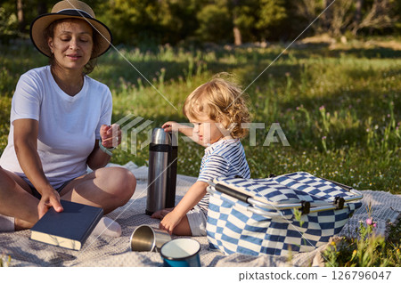 Mother and Child Enjoying a Serenity-Filled Picnic on a Warm Outdoor Day 126796047