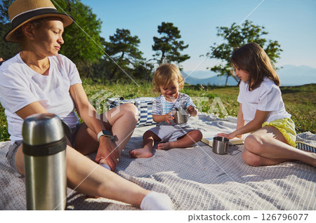 Family Enjoying Quality Time Outdoors During a Picnic in the Countryside Family Enjoying Quality Time Outdoors During a Picnic in the Countryside 126796077