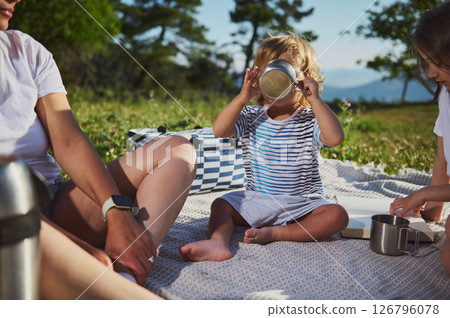 Family Enjoying a Relaxing Outdoor Picnic in a Scenic Mountain Setting Family Enjoying a Relaxing Outdoor Picnic in a Scenic Mountain Setting 126796078