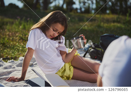 Young Girl Relaxing Outdoors on a Blanket During a Peaceful Day 126796085