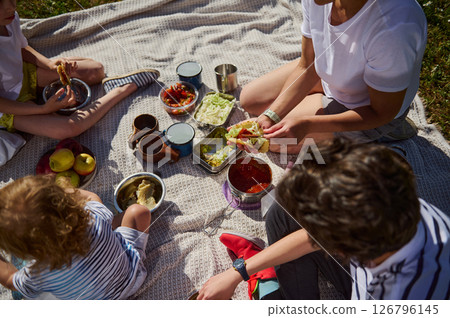 Family Enjoying an Outdoor Picnic Eating Tacos in Nature 126796145