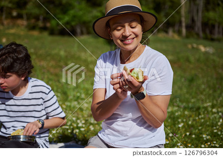 Mother Enjoying a Picnic Outdoors in the Mountains With Her Child Mother Enjoying a Picnic Outdoors in the Mountains With Her Child 126796304