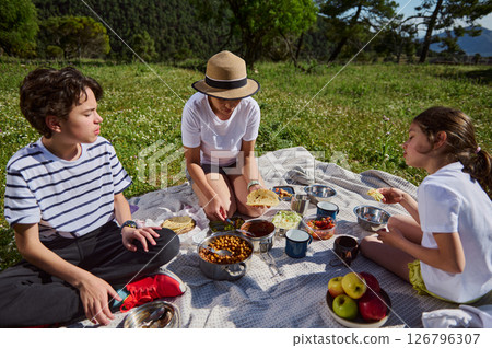 Family Enjoying a Picnic with Tacos in a Scenic Mountain Setting Family Enjoying a Picnic with Tacos in a Scenic Mountain Setting 126796307