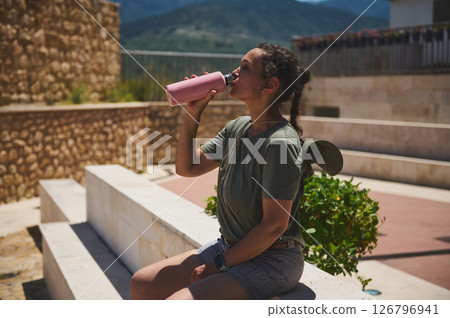 Traveler Relaxing Outdoors While Drinking Water from Bottle Traveler Relaxing Outdoors While Drinking Water from Bottle 126796941
