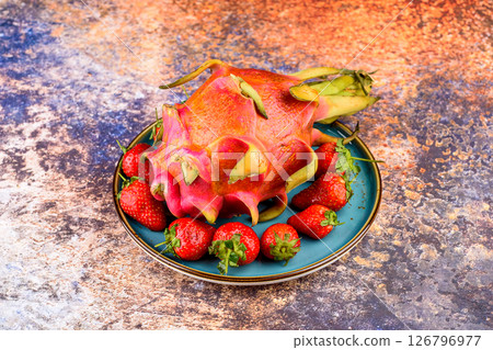 Dragon fruit and strawberries on a white plate. 126796977
