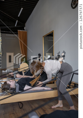 A detailed closeup of a foot work and core exercise on a Balanced Body Reformer machine illuminated by sunlight A detailed closeup of a foot work and core exercise on a Balanced Body Reformer machine illuminated by sunlight 126797371
