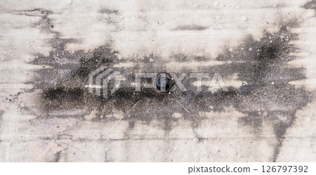 Directly above a white flat roof building drain  126797392