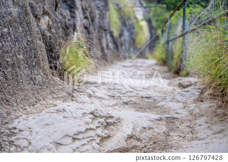 Selective focus on an uneven surface of the hiking trail to the summit of Diamond Head State Monument in Oahu, Hawaii  126797428