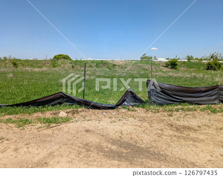 Sagging and damaged stormwater fabric silt fence at a construction site Sagging and damaged stormwater fabric silt fence at a construction site 126797435