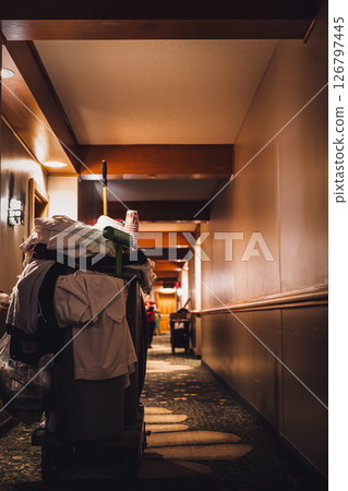 Hotel hallway with room service cleaning cart with supplies. 126797445