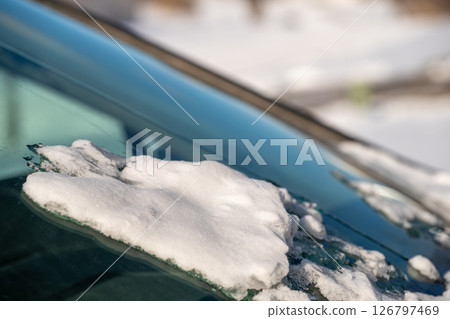 ice and snow on the front windshield of a vehicle. 126797469