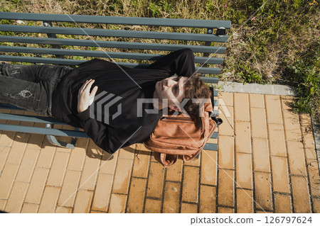 Tired Man Sleeping On His Backpack While On A Bench Outdoor  126797624