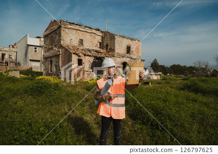 Engineer On The Construction Site Looking At The Old Building  126797625
