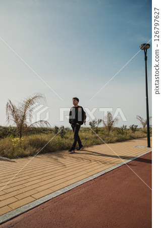 Man With Backpack Taking A Walk In The Nature Near The Grass 126797627
