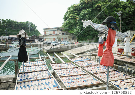 Scarecrow watching over dried fish 126798852