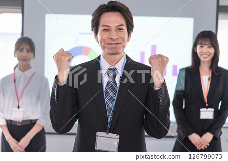 A man pumping his fist in front of a screen in a conference room A man pumping his fist in front of a screen in a conference room 126799073