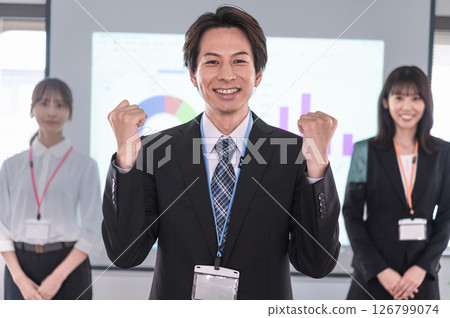 一名男子在會議室的螢幕前揮舞著拳頭 126799074
