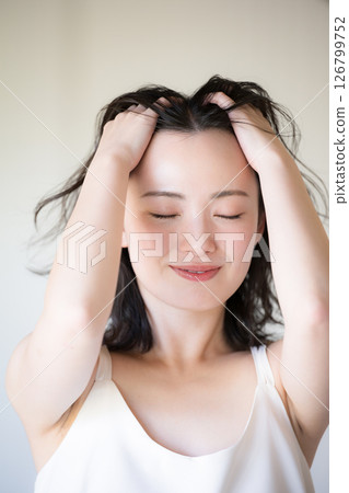Beauty image of a beautiful woman doing hair care, front view 126799752