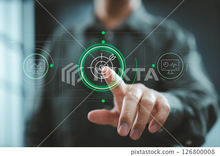 Man pointing at digital target icon with futuristic interface displaying performance metrics and dashboards. 126800008