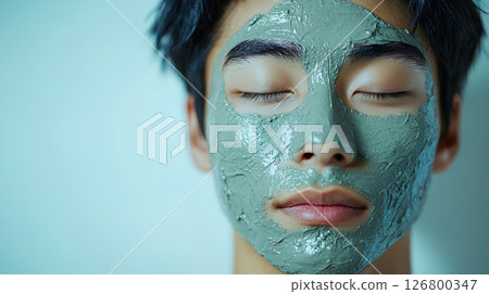 Close-up of a young man's face with a mud pack Close-up of a young man's face with a mud pack 126800347
