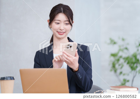 使用智慧型手機的女商人 使用智慧型手機的女商人 126800582