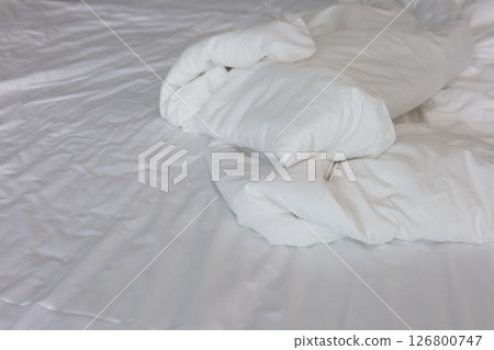 wrinkled white blanket on sheet fabric with soft folds. Ideal for backgrounds, comfort concepts, or bedding-related visuals. wrinkled white blanket on sheet fabric with soft folds. Ideal for backgrounds, comfort concepts, or bedding-related visuals. 126800747