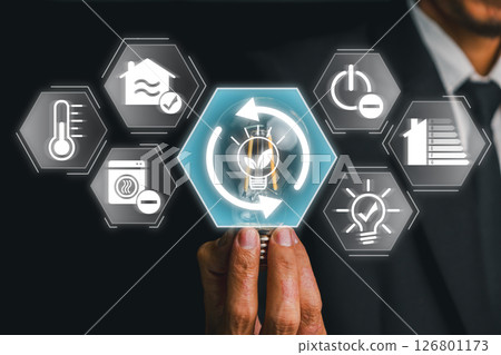 Businessman interacts with futuristic icons representing energy-saving solutions, emphasizing sustainability and efficiency. 126801173
