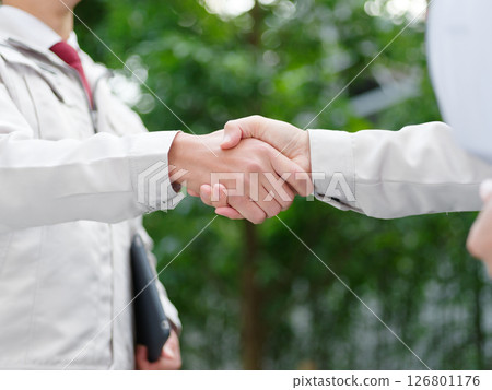 Handshake of men in work clothes 126801176