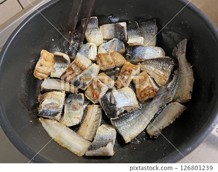 Photographing my mother frying dried flying fish, a Taiwanese specialty snack, in the kitchen 126801239