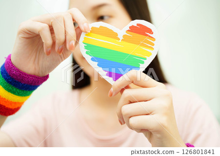 Asian woman holding LGBT heart with rainbow flag. 126801841