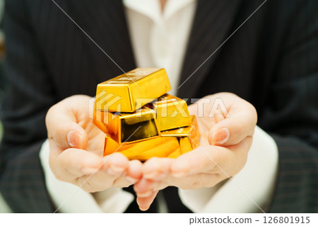 Asian woman holding gold bar in finance business. 126801915