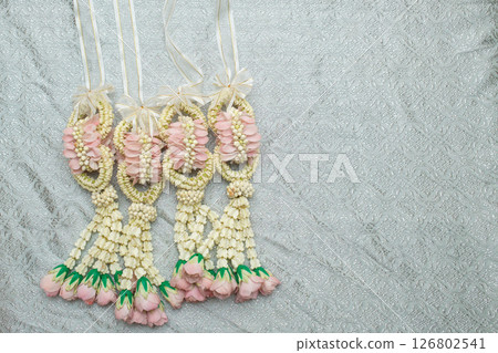 Beautiful Thai-style jasmine garland on a silver cloth background with an ancient Thai pattern. 126802541