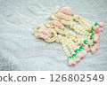 Beautiful Thai-style jasmine garland on a silver cloth background with an ancient Thai pattern. 126802549