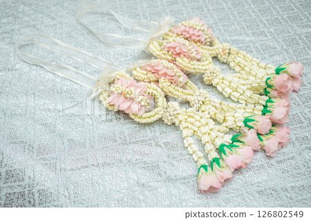 Beautiful Thai-style jasmine garland on a silver cloth background with an ancient Thai pattern. 126802549
