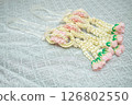 Beautiful Thai-style jasmine garland on a silver cloth background with an ancient Thai pattern. 126802550