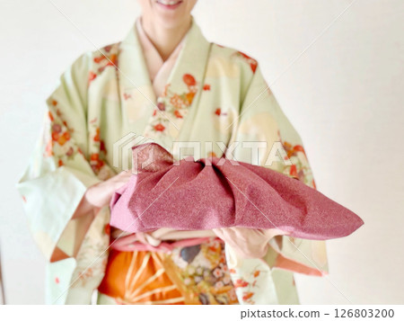 A woman wearing a kimono and carrying a purple furoshiki wrapping cloth A woman wearing a kimono and carrying a purple furoshiki wrapping cloth 126803200
