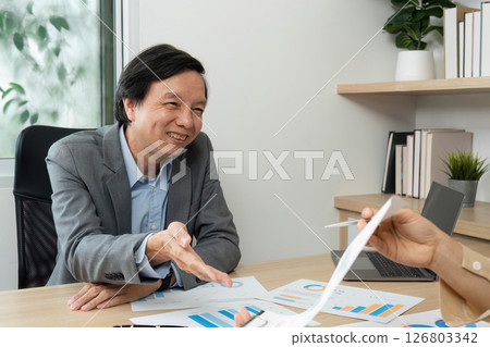 Business Meeting and Collaboration. Professional man smiling and shaking hands during a financial discussion. Business Meeting and Collaboration. Professional man smiling and shaking hands during a financial discussion. 126803342