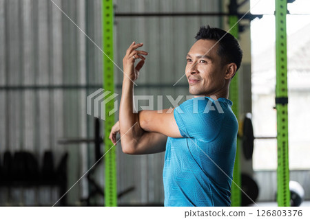 Fitness Stretching Exercise. Man stretching arm in gym. 126803376
