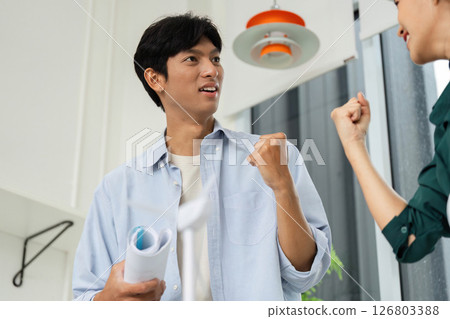 ESG and Sustainability. Excited professional celebrating success in a modern office environment. 126803388