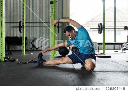 Fitness and Flexibility. Man stretching in a gym for improved mobility. 126803446